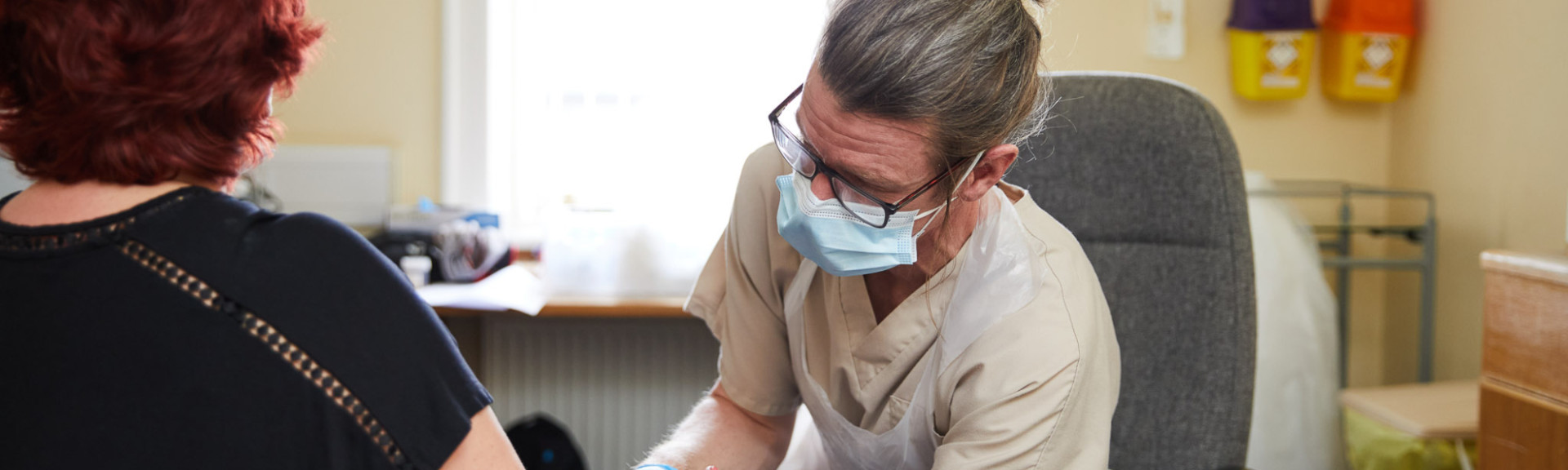 A photo showing a musculoskeletal practitioner reviewing a patients arm