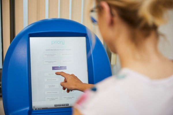 A photo showing a patient using the prioryCARE form on the reception computer