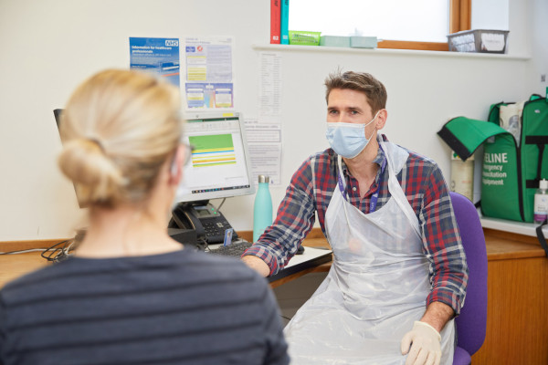 A photo showing Dr Knight speaking to a patient