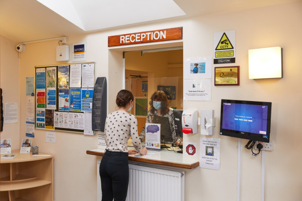 A photo showing a patient at the reception desk at Park View surgery