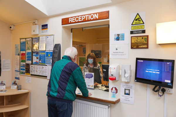 A photo showing a patient at the Park View surgery reception desk